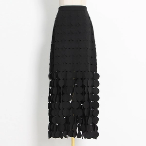 Detail of laser-cut round discs and layered fringe on this black high-waisted midi skirt