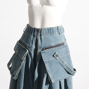Détail du pantalon cargo en denim bleu avec grandes poches utilitaires et zips métalliques