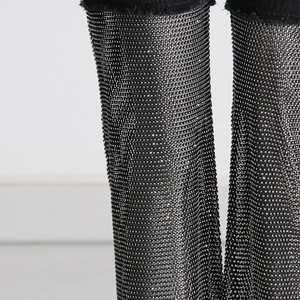 Detailed view of shimmering silver rhinestones and raw edge hems on black denim pants