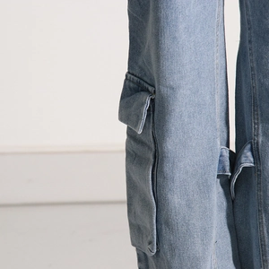 Close-up of the cargo pocket and stitching on light blue washed denim pants