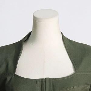Detail of square neckline and tailoring on dark green bone-cinched waist blazer