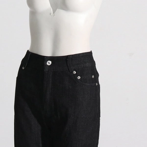 Detail of high waist black jeans showing silver buttons and reinforced rivets