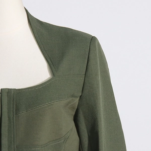 Detail of dark green blazer showing square neckline and contrast decorative stitching