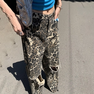 Detail of high-waisted leopard print jeans featuring distressed ripped knees in Y2K style
