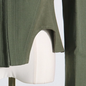Detailed view of olive green corset jacket featuring structural boning and curved hemline