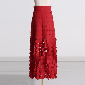 Detail of red high-waisted midi skirt with laser-cut hollow scales and layered design