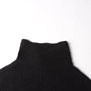 Close-up of the vertical rib-knit texture and smooth neckline on a black turtleneck sweater