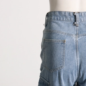 Close-up of light blue vintage denim jeans showing back pocket and waist stitching details