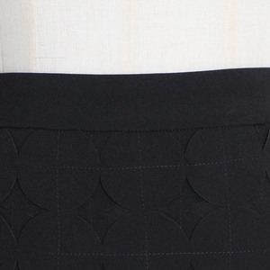 Detailed view of black laser-cut hollow dot patterns on the skirt waist