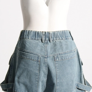Détail d'un jean taille haute avec de grandes poches cargo et des sangles utilitaires bleues