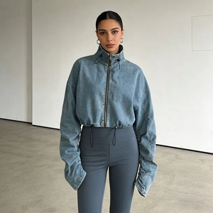 Detail view of washed blue denim jacket featuring high collar drawstring and metal zipper