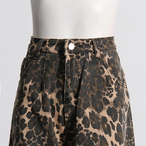 Detailed macro view of leopard print denim fabric with silver button and belt loops