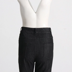 Detailed back view of high-waist denim trousers with rhinestones and fishnet stitching