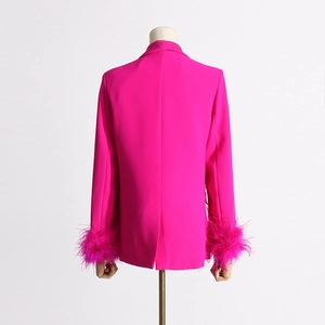 Detail of rose pink blazer featuring luxury ostrich feather cuffs and sparkling crystal collar