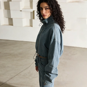 Detail of blue wash denim jacket with high collar drawstring and zip closure