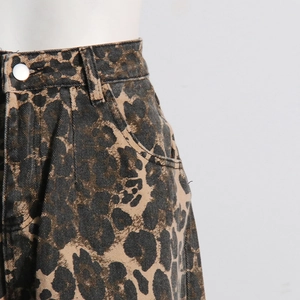 Detail of high-waist leopard print denim pants showing metal button and pocket structure
