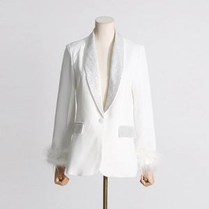 Detailed view of the diamond neckline and ostrich feather cuffs on a white luxury blazer