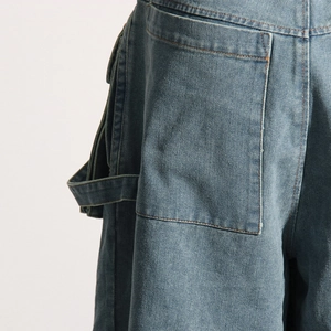 Détail d'un jean taille haute avec grande poche arrière et boucle de menuisier