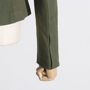 Detailed close-up of the olive green blazer sleeve with slit vent and fine stitching