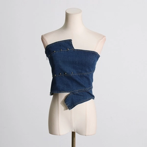Detailed shot of dark blue denim tube top with golden rivets and asymmetric cut-off edges