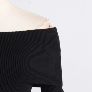 Detail des schwarzen schulterfreien Strickpullovers mit feiner Rippstruktur und Passform