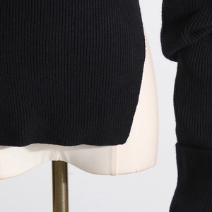 Detailansicht des Seitenschlitzes und der Rippstrick-Struktur am schwarzen Pullover
