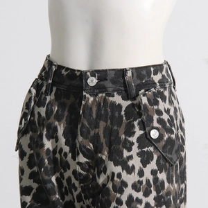 Close-up of leopard print cargo pants showing waist detail and metallic silver button