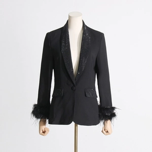 Detailed view of rhinestone lapels and ostrich feather cuffs on a black blazer