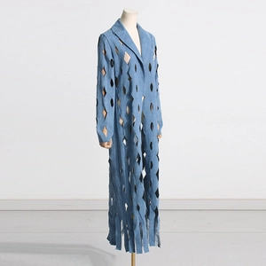 Detail view of light blue denim coat with diamond cut-outs and long fringe hem