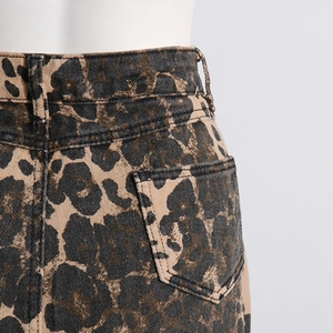 Detailed close-up of leopard print denim fabric with waist pockets and stitching