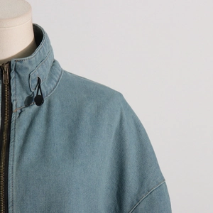 Detail view of denim jacket high neck with metal zipper and adjustable drawstring cord