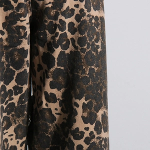Detailed macro view of vintage leopard print denim fabric with a textured twill weave