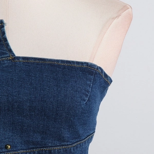 Close-up of deep blue denim top showing yellow stitching and fabric texture details