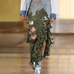 Detail of army green irregular cutout skirt with fringe edges and deconstructed design