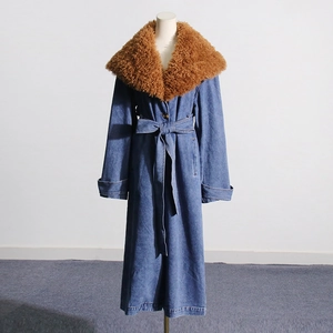 Detail shot of blue denim coat featuring a large detachable brown faux fur collar