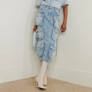 Detailed view of light blue washed denim cargo skirt with multiple pockets and ribbons