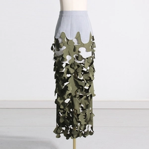 Detail of laser-cut leaf patterns on a green camouflage layered long skirt design