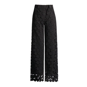 Detailed view of black high-waisted wide-leg pants with geometric cutout embroidery