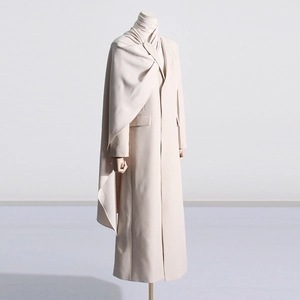 Close-up of elegant beige long coat with a stylish integrated scarf draping detail