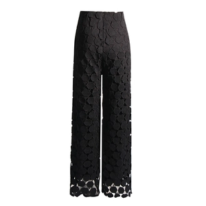 Detailed close-up of high-waist trousers with geometric hexagonal hollow embroidery