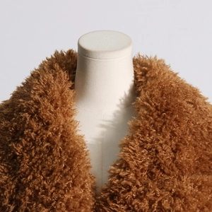 Detail of the soft faux fur collar and caramel brown fluffy texture on the trench coat