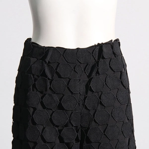 Detailed view of black high-waisted pants featuring unique 3D hexagonal honeycomb texture