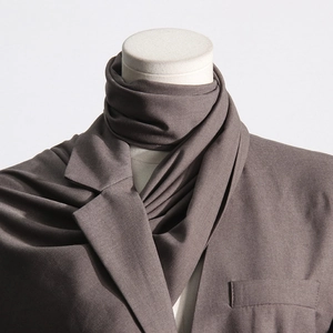 Detail of a dark brown blazer with a scarf design and textured matte fabric on a mannequin