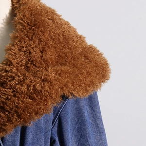 Detail of blue denim jacket showing a thick brown faux fur collar and fabric texture