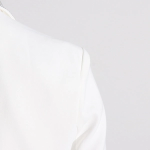 Detailed view of white blazer shoulder seam and internal shoulder pad construction