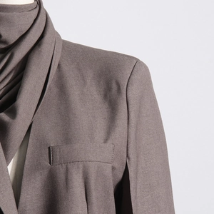 Close-up of premium coffee brown blazer with structured shoulder and draped scarf detail