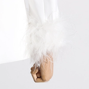 Detail of white blazer sleeve featuring premium ostrich feather trim on the cuff
