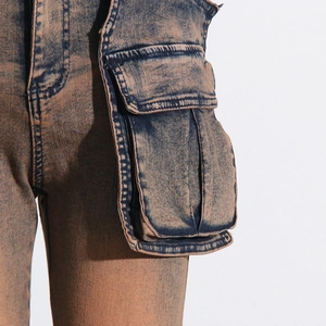 Detailed view of cargo side pocket on vintage washed denim pants with flap design