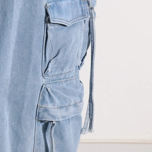 Detail shot of side cargo pockets and straps on washed denim mid-length skirt