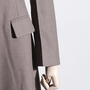 Detail view of coffee brown suit jacket featuring flap pocket and smooth fabric texture